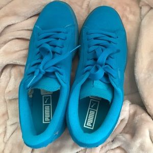 Woman’s blue Pumas athletic shoes